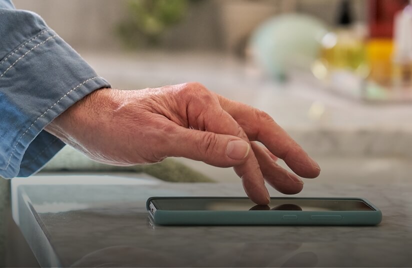 Thumbnail for a video called Tabletop Test, showing a hand with Dupuytren's contracture using a smartphone flat on a table